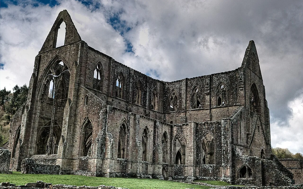 The roofless shell of Tintern Abbey against a heavy sky